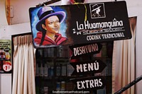 Indigenous woman with hat, wooden sign of a restaurant in Ayacucho. Peru, South America.