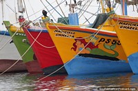 Coloridos cascos de barcos de pesca en fila en Paracas, amarillo, rojo, verde y blanco. Perú, Sudamerica.