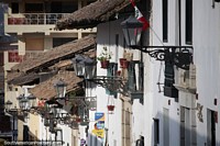 Postes de luz, vasos de plantas e telhados, rua da cidade em Cajamarca.
