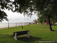 Versión más grande de El parque cubierto de hierba en el puerto de Paysandú que pasa por alto el Río de Uruguay.