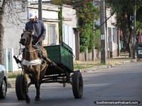 O cavalo e a carreta trotam ao longo da rua em Tacuarembo. Uruguai, América do Sul.