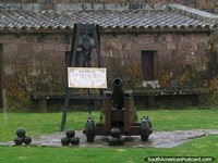 Larger version of A black cannon with cannon balls in front at Fort San Miguel in Chuy.