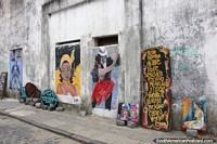 Versión más grande de Murales y arte a lo largo de la acera en una calle ordinaria en Colonia del Sacramento.