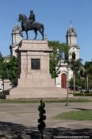 Jose Artigas (1764-1850) on horseback and the cathedral behind at Plaza Artigas in Salto. Uruguay, South America.