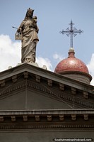 The cupola (dome), cross and statue at the top of the cathedral in Mercedes. Uruguay, South America.