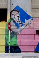Young man with microphone sings, colorful street art in Montevideo.
