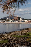 View across the rocks and still waters to the beach, city and mountain in Piriapolis. Uruguay, South America.