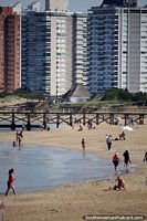 Playa Mansa, embarcadero y apartamentos, gente caminando por la mañana en Punta del Este. Uruguay, Sudamerica.