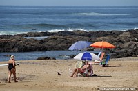Praia Brava, tome uma cadeira e guarda-chuva e sente-se nas areias olhando as ondas cair em, Punta do Este. Uruguai, América do Sul.