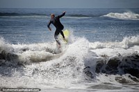 O surfe é o nome do jogo em Praia Brava onde as ondas entram, surfista na ação em Punta do Este. Uruguai, América do Sul.