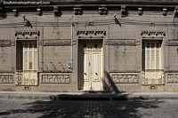 Decorated facade on a cobblestone road in Rocha with iron window railing, quite attractive. Uruguay, South America.