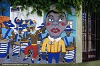 Versión más grande de Tiempo de carnaval con bailarines disfrazados y músicos en bongos, mural en Rocha.