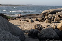 Rocky foreground and secluded sands of Fishermans Beach, Punta del Diablo. Uruguay, South America.