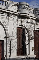 Fachada de edifïcio antiga fantástica que olha em Melo com pátio, folhas de janela de janela de madeira e arcos. Uruguai, América do Sul.