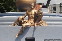 Man holding fruits, gold monument in Maturin.