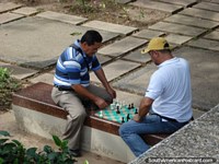 2 men play chess in Plaza Simon Bolivar in San Cristobal. Venezuela, South America.