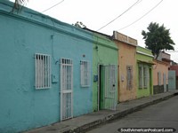 Casas de verde-azulado, verde e laranja em uma rua de Porto Cabello. Venezuela, América do Sul.