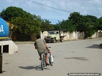 Venezuela Photo - Boy rides home on bicycle with a fresh fish in hand in Robledal, Isla Margarita.