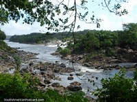 O leito fluvial rochoso de Rio Caroni examina de Parque Cachamay, Cidade Guayana. Venezuela, América do Sul.
