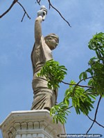 O homem mantém a tocha em cima do monumento de Praça Libertad em Maracaibo. Venezuela, América do Sul.