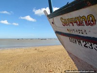 Um barco de pesca na areia indica a outros barcos de pesca na água em La Vela de Coro. Venezuela, América do Sul.
