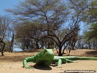 Um monumento de iguana verde gigantesco senta-se na terra no parque em Coro. Venezuela, América do Sul.
