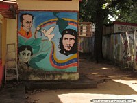 Versión más grande de Simon Bolivar, Che Guevara y otro hombre representados en el arte de la pared en una escuela en Barinas.