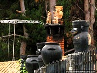 Larger version of Ceramic voodoo creatures sit on peoples roofs in San Isidro de Apartaderos.