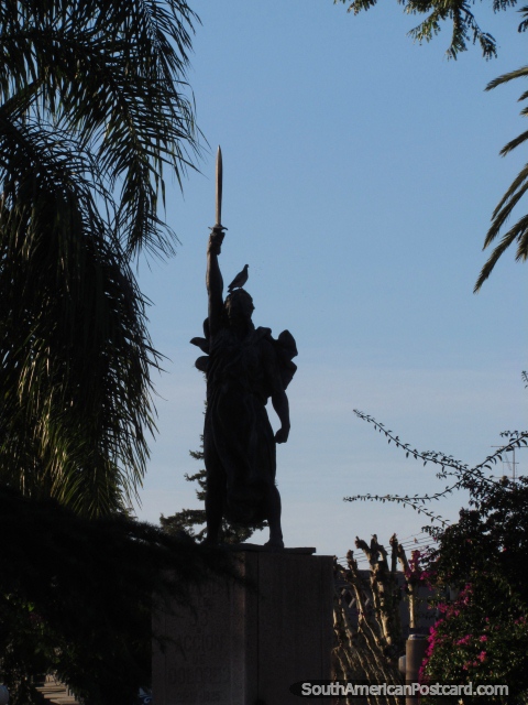 Monument in Plaza Constitucion in Dolores, man with sword in the air, pigeon on head. (480x640px). Uruguay, South America.