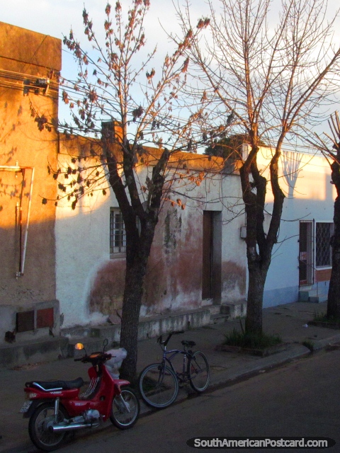 El scooter y la bicicleta se sientan fuera de una casa en Palmira. (480x640px). Uruguay, Sudamerica.