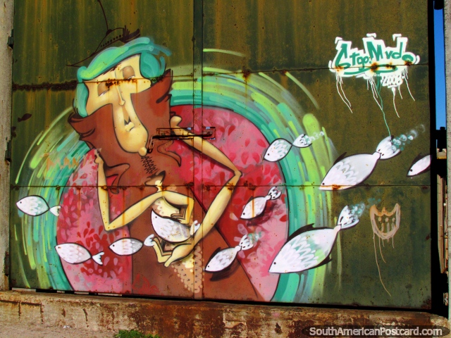 El hombre toca el pescado, arte de graffiti en una puerta de hierro en Montevideo. (640x480px). Uruguay, Sudamerica.