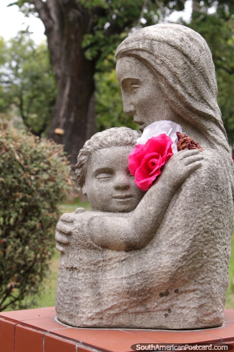 Una escultura de piedra de una madre y su hijo llamado Madre en la Plaza 25 de Agosto en Colonia. (480x720px). Uruguay, Sudamerica.