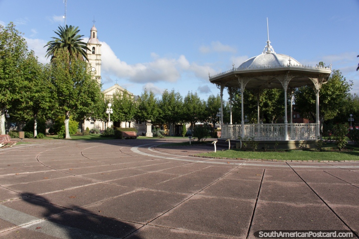 Plaza Constitucin con kiosco central y la iglesia en la distancia en Fray Bentos. (720x480px). Uruguay, Sudamerica.