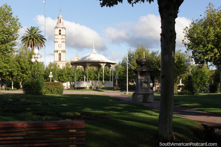 Plaza Constitucion, stone monument, kiosk and church tower, Fray Bentos. (720x480px). Uruguay, South America.