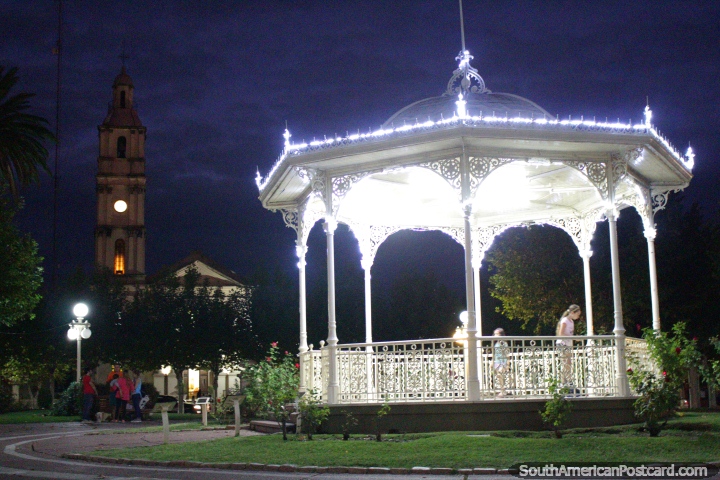 Plaza Constitucion at night with the kiosk and distant church, Fray Bentos. (720x480px). Uruguay, South America.