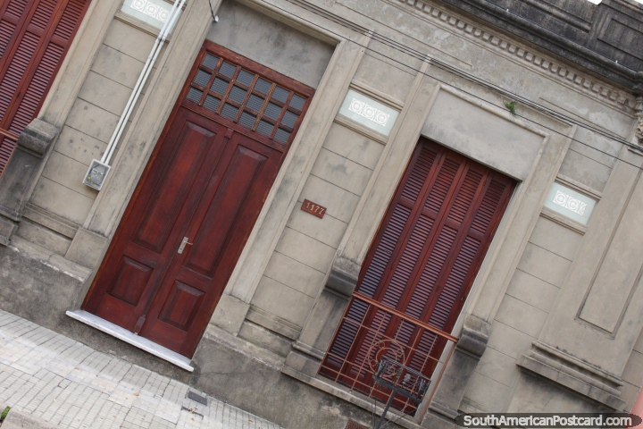 Un antiguo edificio con puerta de madera, ventanas y persianas en Fray Bentos. (720x480px). Uruguay, Sudamerica.
