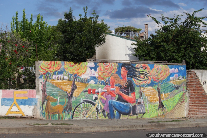 Chico y nia en una bicicleta en el campo, colorido mural en Fray Bentos. (720x480px). Uruguay, Sudamerica.