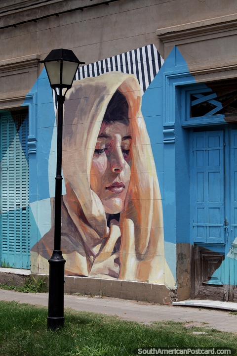 Señorita con una capucha que cubre su cabeza, una hermosa obra de arte callejero en Paysandú. (480x720px). Uruguay, Sudamerica.
