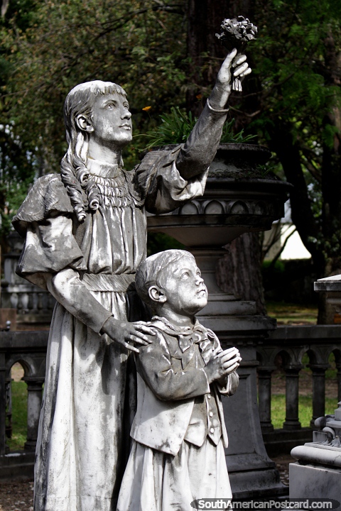 Mulher e criança, apoia flores, monumento de pedra no cemitério velho em Paysandu. (480x720px). Uruguai, América do Sul.