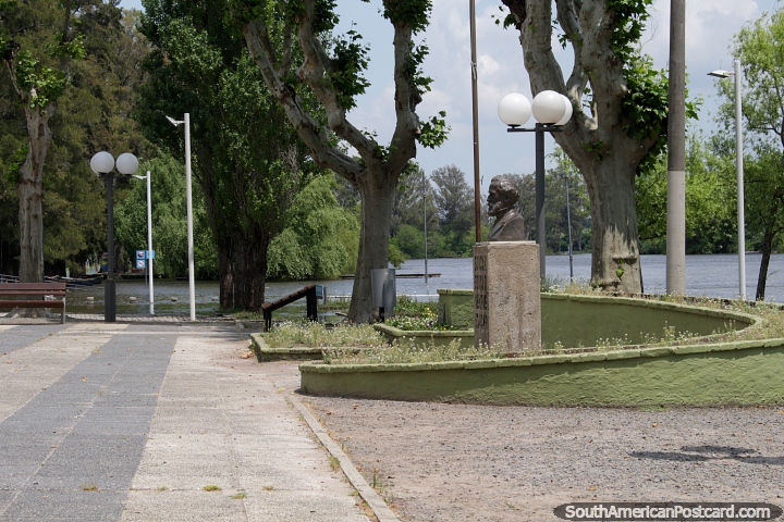 Plaza, monument and big trees down at the picturesque riverfront in Mercedes. (720x480px). Uruguay, South America.