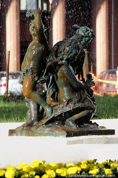 Fuente con figuras de bronce y jardines de flores en la Plaza Independencia de Montevideo. (480x720px). Uruguay, Sudamerica.