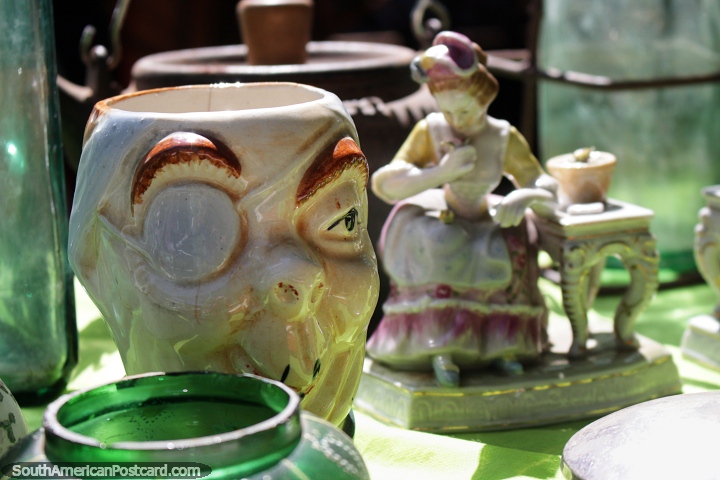 Ceramic antiques, a large mug with eye and a woman at a table, Sunday market in Montevideo. (720x480px). Uruguay, South America.