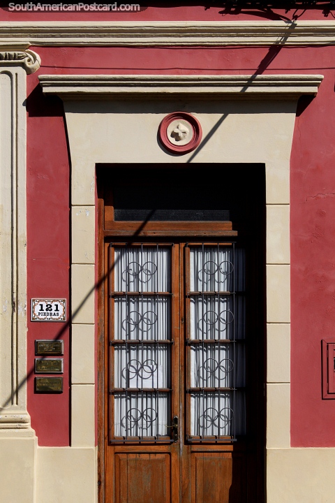 Wine and cream colored facade with a wooden door in Rocha, very stylish. (480x720px). Uruguay, South America.