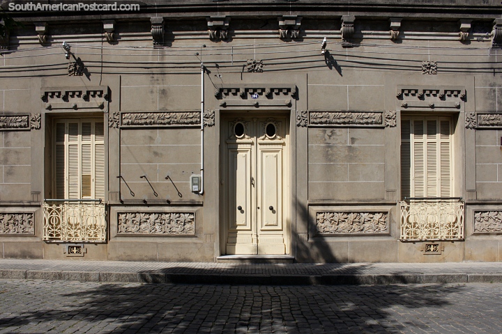 Decorated facade on a cobblestone road in Rocha with iron window railing, quite attractive. (720x480px). Uruguay, South America.
