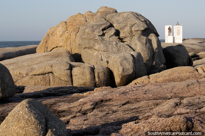 Large boulder in the shape of a brain and the distant lighthouse monument at Punta del Diablo. (720x480px). Uruguay, South America.