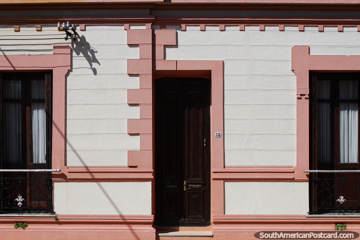 Fachada de uma casa, desenho a cores e elegante rosa com porta de madeira e janelas, Tacuarembo. (720x480px). Uruguai, América do Sul.