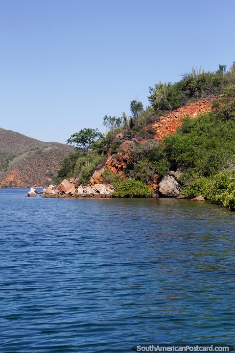 Rocks and boulders and cactus hills beside the sea at Mochima National ...
