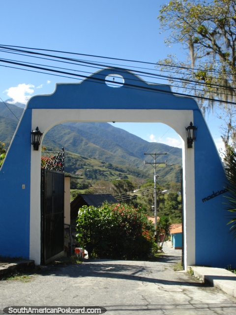 Vista a través de una puerta azul a propiedades en las colinas de Mérida. (480x640px). Venezuela, Sudamerica.