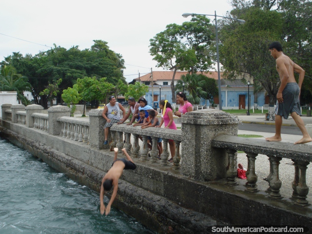 Os habitantes locais de Porto Cabello mergulham-se do pilar de ponte no Dia de Anos Novos 2011. (640x480px). Venezuela, América do Sul.
