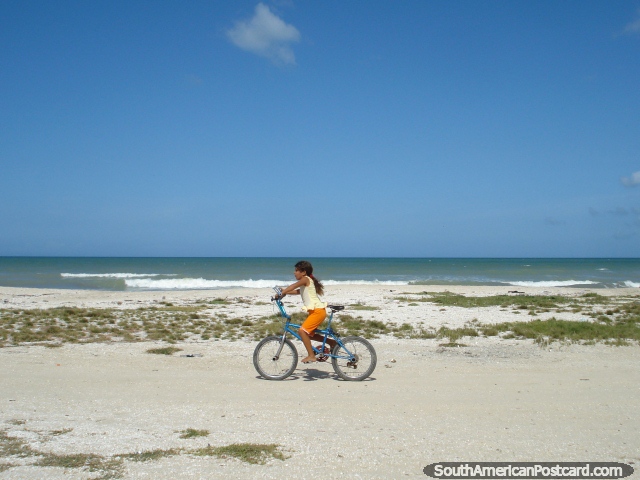 A menina anda em uma bicicleta ao longo da praia de La Restinga em Ilha Margarita. (640x480px). Venezuela, Amrica do Sul.